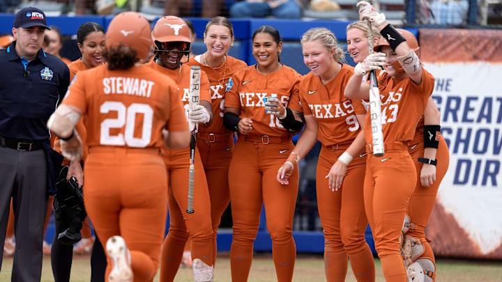 Texas players greet Katie Stewart (20) at home plate after she hit a home run in the in the sixth inning of a Women's College World Series softball game between the Texas Longhorns and the Florida Gators at Devon Park in Oklahoma City, Thursday, May 29, 2025.