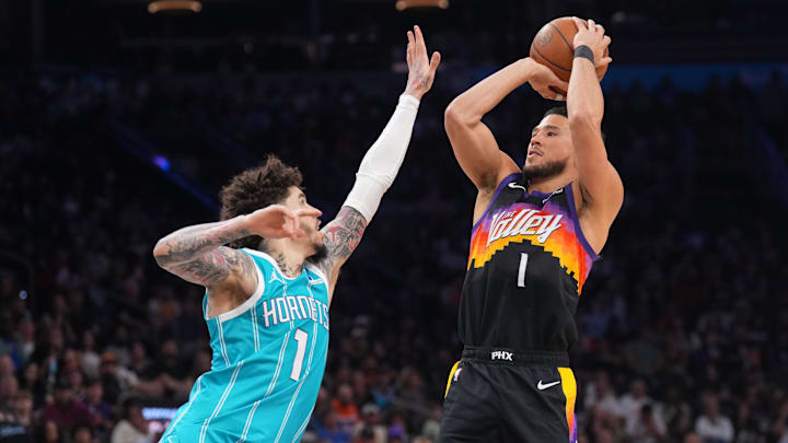 Mar 8, 2026; Phoenix, Arizona, USA; Phoenix Suns guard Devin Booker (1) shoots over Charlotte Hornets guard LaMelo Ball (1) during the second half at Mortgage Matchup Center. Mandatory Credit: Joe Camporeale-Imagn Images