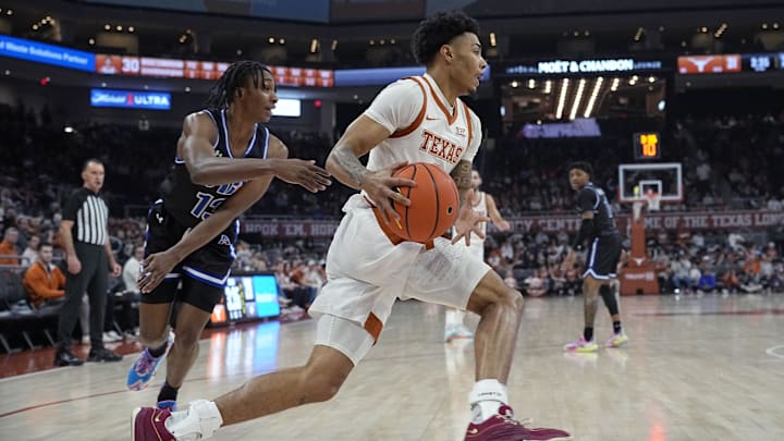 Jan 1, 2024; Austin, Texas, USA; Texas Longhorns guard Chris Johnson (0) drives to the basket past Texas-Arlington Mavericks guard Kade Douglas (13) during the first half at Moody Center. Mandatory Credit: Scott Wachter-Imagn Images