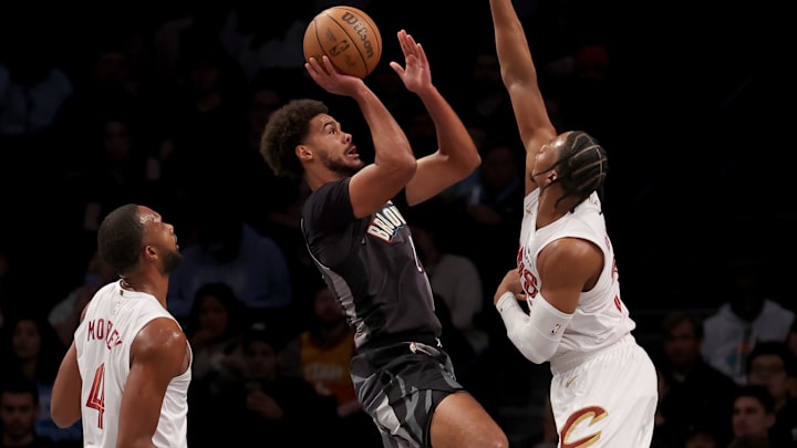 Dec 16, 2024; Brooklyn, New York, USA; Brooklyn Nets forward Cameron Johnson (2) takes a shot against Cleveland Cavaliers forwards Isaac Okoro (35) and Evan Mobley (4) during the first quarter at Barclays Center. Mandatory Credit: Brad Penner-Imagn Images