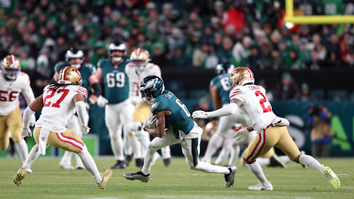 Jan 11, 2026; Philadelphia, PA, USA; Philadelphia Eagles wide receiver DeVonta Smith (6) carries the ball after a reception defended by San Francisco 49ers safety Ji'ayir Brown (27) and cornerback Deommodore Lenoir (2) during the second quarter in an NFC Wild Card Round game at Lincoln Financial Field. Mandatory Credit: Bill Streicher-Imagn Images Jan 11, 2026; Philadelphia, PA, USA; Philadelphia Eagles wide receiver DeVonta Smith (6) carries the ball after a reception defended by San Francisco 49ers safety Ji'ayir Brown (27) and cornerback Deommodore Lenoir (2) during the second quarter in an NFC Wild Card Round game at Lincoln Financial Field. Mandatory Credit: Bill Streicher-Imagn Images