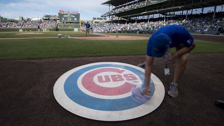 Jun 19, 2017; Chicago, IL, USA; A member of the grounds crew wipes off the Chicago Cubs' on deck logo prior to a game against the San Diego Padres at Wrigley Field. Mandatory Credit: Patrick Gorski-Imagn Images