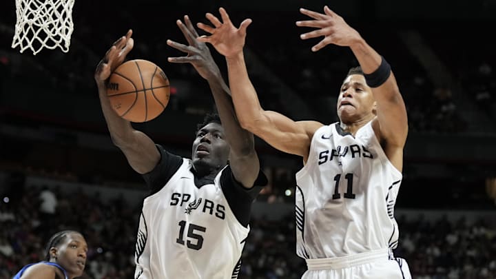 Jul 12, 2025; Las Vegas, NV, USA; San Antonio Spurs forward Ibrahima Diallo (15) and forward Carter Bryant (11) jump for a rebound in the third quarter of their game against the Dallas Mavericks at Thomas & Mack Center. Mandatory Credit: Candice Ward-Imagn Images
