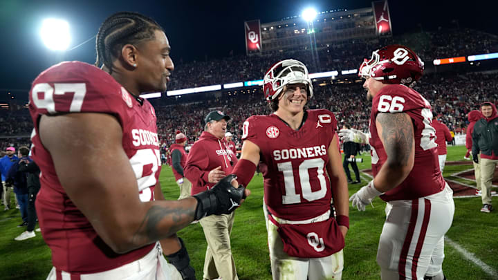 Oklahoma quarterback John Mateer (10) celebrates with defensive lineman Marvin Jones Jr. (97) and offensive lineman Derek Simmons (66) after their win over LSU at Gaylord Family – Oklahoma Memorial Stadium in Norman on Nov. 29. Oklahoma won 17-13. Oklahoma quarterback John Mateer (10) celebrates with defensive lineman Marvin Jones Jr. (97) and offensive lineman Derek Simmons (66) after their win over LSU at Gaylord Family – Oklahoma Memorial Stadium in Norman on Nov. 29. Oklahoma won 17-13.