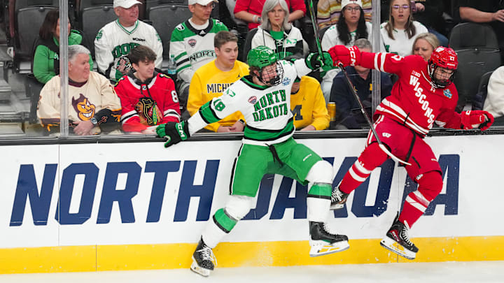 Apr 9, 2026; Las Vegas, Nevada, UNITED STATES; North Dakota Fighting Hawks defenseman Keaton Verhoeff (18) is checked by Wisconsin Badgers forward Finn Brink (27) in the first period in the semifinals of the NCAA men's ice hockey Frozen Four at T-Mobile Arena. Mandatory Credit: Stephen R. Sylvanie-Imagn Images