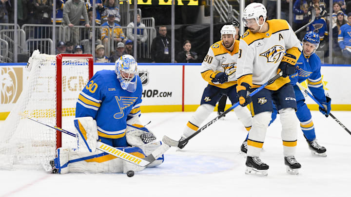 Dec 27, 2025; St. Louis, Missouri, USA; St. Louis Blues goaltender Joel Hofer (30) defends the net against Nashville Predators left wing Filip Forsberg (9) during the third period at Enterprise Center. Mandatory Credit: Jeff Curry-Imagn Images