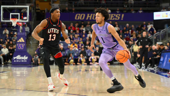 Dec 29, 2025; Seattle, Washington, USA; Washington Huskies guard Desmond Claude (1) dribbles the ball while guarded by Utah Utes forward Kendyl Sanders (13) during the first half at Alaska Airlines Arena at Hec Edmundson Pavilion. Mandatory Credit: Steven Bisig-Imagn Images