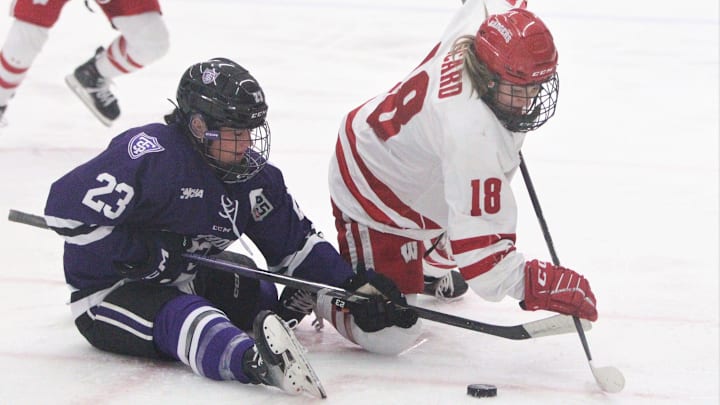 Wisconsin's Marianne Picard (18) fights for the puck after a faceoff with St. Thomas' Brieja Parent on Saturday March 2, 2024 at LaBahn Arena in Madison, Wisconsin.