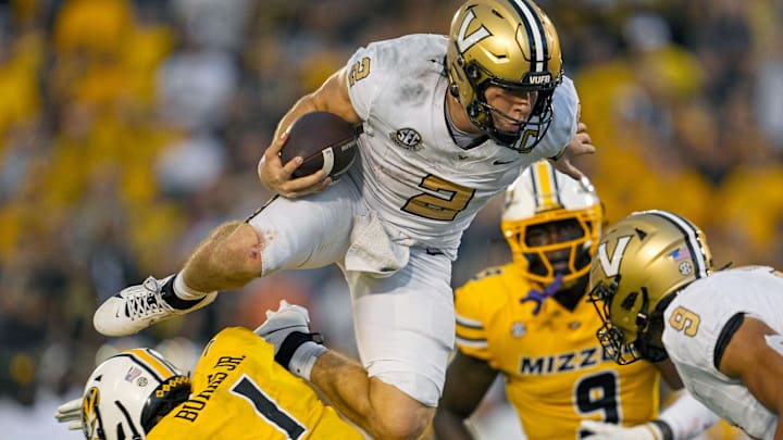 Sep 21, 2024; Columbia, Missouri, USA; Vanderbilt Commodores quarterback Diego Pavia (2) leaps over Missouri Tigers safety Marvin Burks Jr. (1) during overtime at Faurot Field at Memorial Stadium. Mandatory Credit: Jay Biggerstaff-Imagn Images