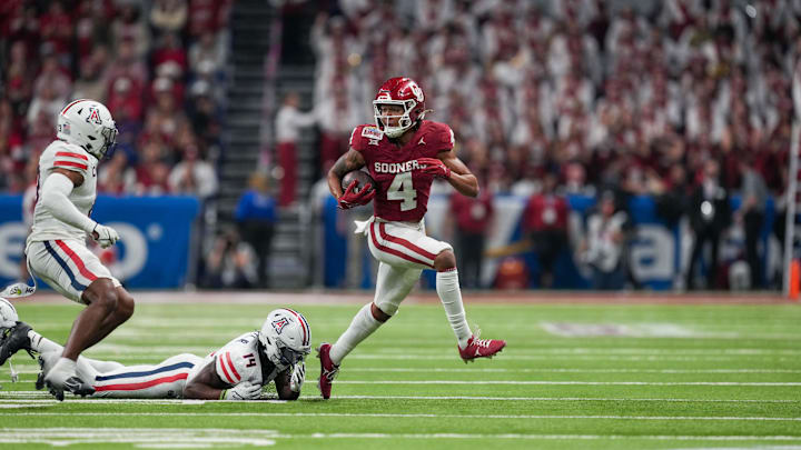 Dec 28, 2023; San Antonio, TX, USA; Oklahoma Sooners wide receiver Nic Anderson (4) runs from Arizona Wildcats safety DJ Warnell Jr. (14) in the second half at Alamodome. Mandatory Credit: Daniel Dunn-Imagn Images