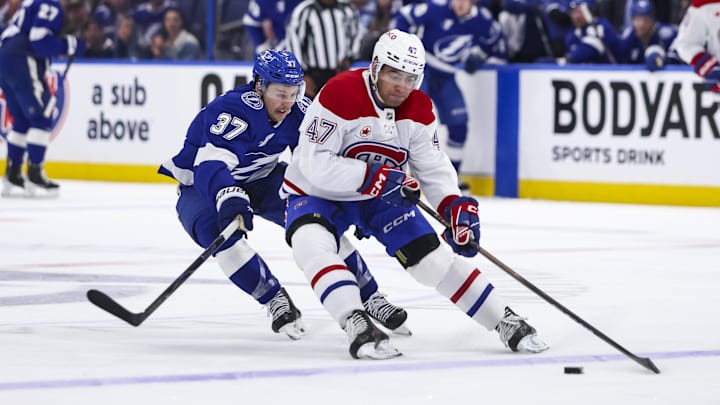 Apr 19, 2026; Tampa, Florida, USA; Montreal Canadiens defenseman Jayden Struble (47) shields the puck from Tampa Bay Lightning forward Yanni Gourde (37) during the first period in game one of the first round of the 2026 Stanley Cup Playoffs at Benchmark International Arena. Mandatory Credit: Morgan Tencza-Imagn Images