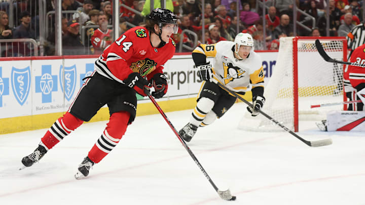 Apr 6, 2025; Chicago, Illinois, USA; Chicago Blackhawks defenseman Kevin Korchinski (14) skates with the puck against the Pittsburgh Penguins during the second period at United Center. Mandatory Credit: Talia Sprague-Imagn Images