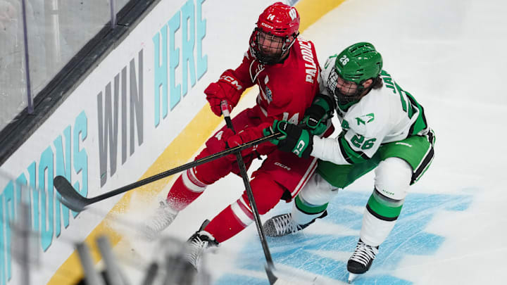 Apr 9, 2026; Las Vegas, Nevada, UNITED STATES; Wisconsin Badgers defenseman Joe Palodichuk (14) and North Dakota Fighting Hawks forward Dylan James (26) battle for the puck in the first period in the semifinals of the NCAA men's ice hockey Frozen Four at T-Mobile Arena. Mandatory Credit: Stephen R. Sylvanie-Imagn Images