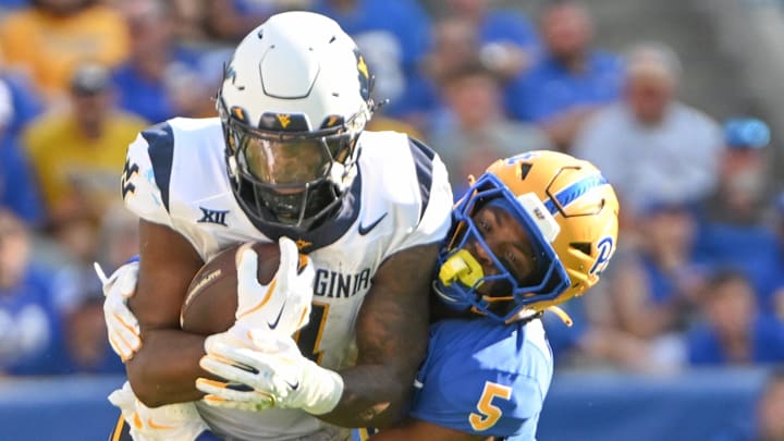 Sep 14, 2024; Pittsburgh, Pennsylvania, USA; Pittsburgh Panthers defensive back Phillip O'Brien Jr. (5) tackles West Virginia Mountaineers running back CJ Donaldson Jr. (4) during the second quarter at Acrisure Stadium. Mandatory Credit: Barry Reeger-Imagn Images