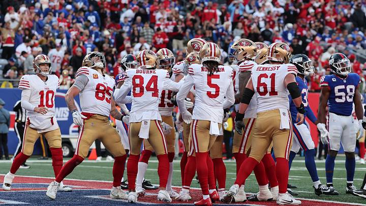 Nov 2, 2025; East Rutherford, New Jersey, USA; San Francisco 49ers tight end George Kittle (85) spikes the ball off the head of running back Christian McCaffrey (23) after he scored a touchdown against the New York Giants during the second half at MetLife Stadium. Mandatory Credit: Ed Mulholland-Imagn Images