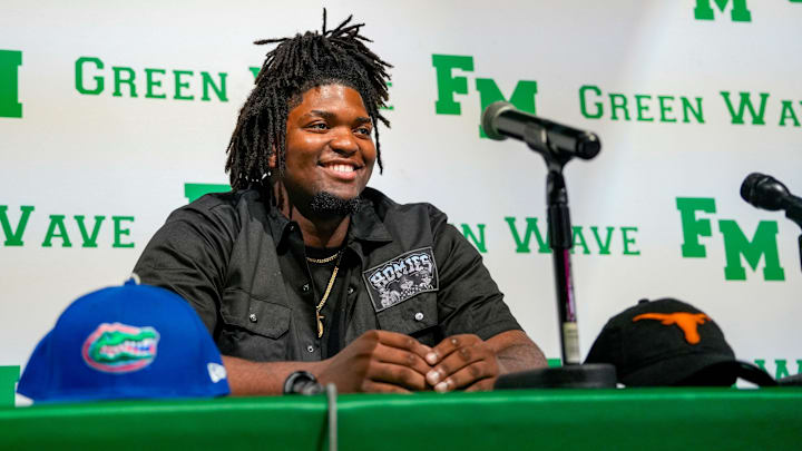 Fort Myers Green Wave defensive lineman Kendall Guervil commits to the University of Florida while surrounded by friends and family during a ceremony at Fort Myers High School in Fort Myers, Fla., on Wednesday, July 2, 2025.