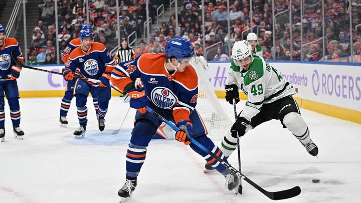Nov 25, 2025; Edmonton, Alberta, CAN;  Edmonton Oilers centre Connor Clattenburg (64) chases the puck with Dallas Stars centre Justin Hryckowian (49) during the second period at Rogers Place. Mandatory Credit: Walter Tychnowicz-Imagn Images