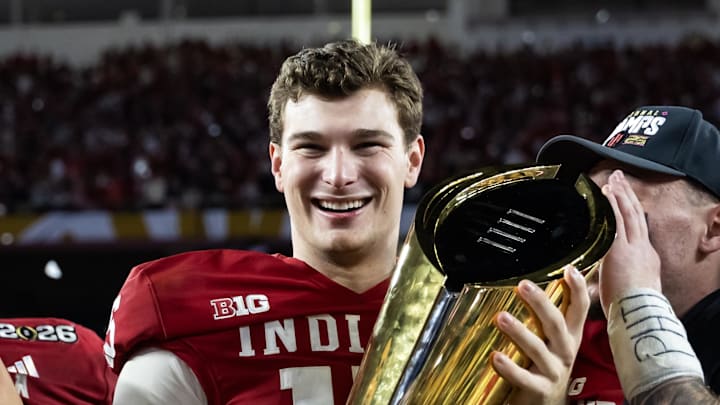 Jan 19, 2026; Miami Gardens, FL, USA; Indiana Hoosiers quarterback Fernando Mendoza (16) celebrates with the trophy after defeating the Miami Hurricanes in the College Football Playoff National Championship game at Hard Rock Stadium. Mandatory Credit: Mark J. Rebilas-Imagn Images