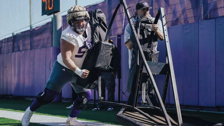 Parker Cross takes on a blocking sled under offensive-line coach Brennan Carroll's close watch.
