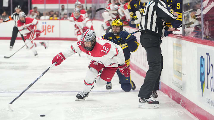 Feb 2, 2024; Columbus, Ohio, USA; Ohio State Buckeyes forward Caden Brown (12) skates past Michigan Wolverines forward Dylan Duke (25) during the NCAA men   s hockey game at Value City Arena.