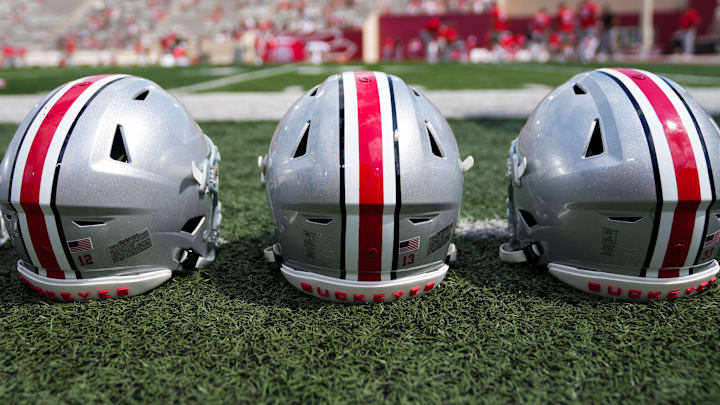 Sep 2, 2023; Bloomington, Indiana, USA; Ohio State Buckeyes helmets sit on the sideline prior to the NCAA football game at Indiana University Memorial Stadium. Sep 2, 2023; Bloomington, Indiana, USA; Ohio State Buckeyes helmets sit on the sideline prior to the NCAA football game at Indiana University Memorial Stadium.