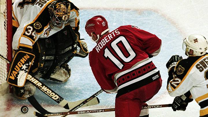 26 Apr 1999: Goalie Byron Dafoe #34 of the Boston Bruins blocks the shot to the goal by Gary Roberts #10 of the Carolina Hurricanes during the Eastern Conference Quarter Finals Game Three at the Fleet Center in Boston, Massachusetts. The Hurricanes defeated the Bruins 2-1.