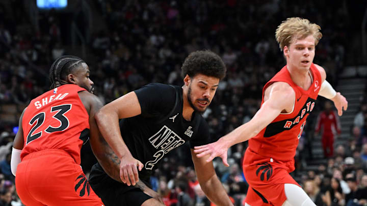 Jan 1, 2025; Toronto, Ontario, CAN;  Brooklyn Nets forward Cam Johnson (2) has the ball stolen against Toronto Raptors guards Jamal Shead (23) and Gradey Dick (1) in the first half at Scotiabank Arena. Mandatory Credit: Dan Hamilton-Imagn Images
