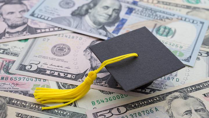 Graduation cap university or college degree on US dollars banknotes background. Graduation cap university or college degree on US dollars banknotes background.