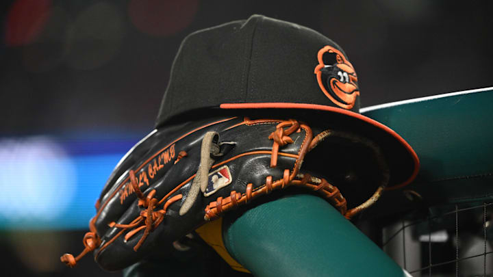 May 8, 2024; Washington, District of Columbia, USA; A Baltimore Orioles hat and glove rest on the dugout rail during a game against the Washington Nationals at Nationals Park.