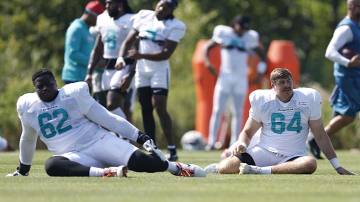 Miami Dolphins guard Germain Ifedi (62) and offensive tackle Daniel Brunskill (64) stretch during joint training camp practice with the Chicago Bears ahead of Sunday's preseason opener. 