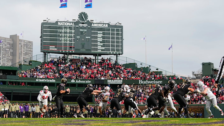Northwestern Wildcats quarterback Jack Lausch (12) drops back to pass during the first half of the NCAA football game against the Ohio State Buckeyes at Wrigley Field in Chicago on Saturday, Nov. 16, 2024.
