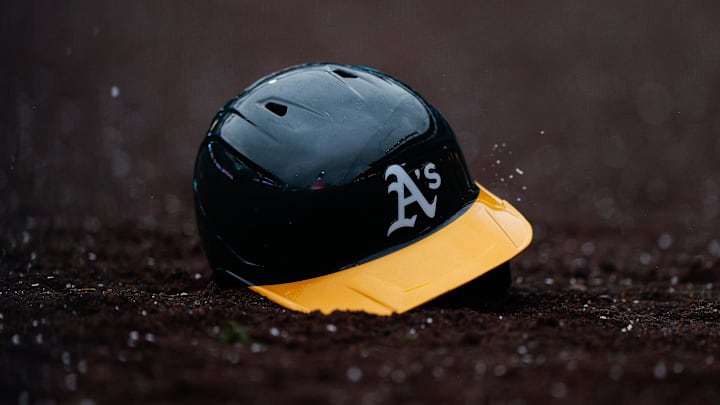 Apr 4, 2025; Denver, Colorado, USA; An Athletics helmet sits in the dirt after being thrown in the tenth inning against the Colorado Rockies at Coors Field. Mandatory Credit: Isaiah J. Downing-Imagn Images
