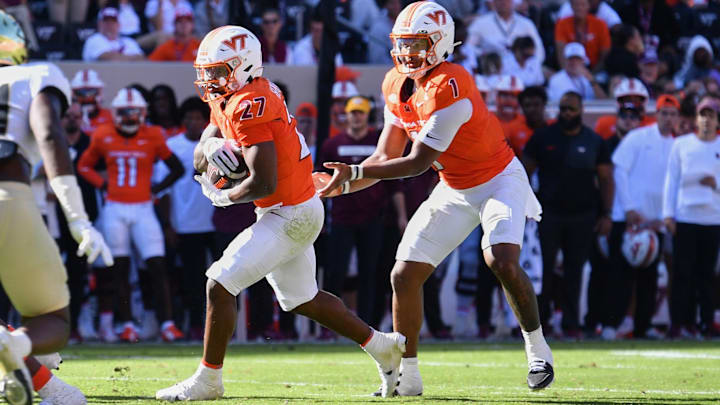 Oct 4, 2025; Blacksburg, Va.; Virginia Tech quarterback Kyron Drones (1) hands the ball to running back Marcellous Hawkins (27). Oct 4, 2025; Blacksburg, Va.; Virginia Tech quarterback Kyron Drones (1) hands the ball to running back Marcellous Hawkins (27).