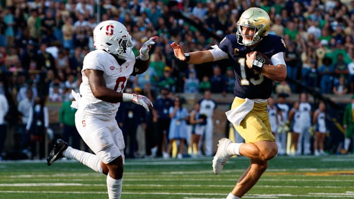 Notre Dame quarterback Riley Leonard (13) reaches out to stiff arm Stanford linebacker Gaethan Bernadel (0) during a NCAA college football game between Notre Dame and Stanford at Notre Dame Stadium on Saturday, Oct. 12, 2024, in South Bend.