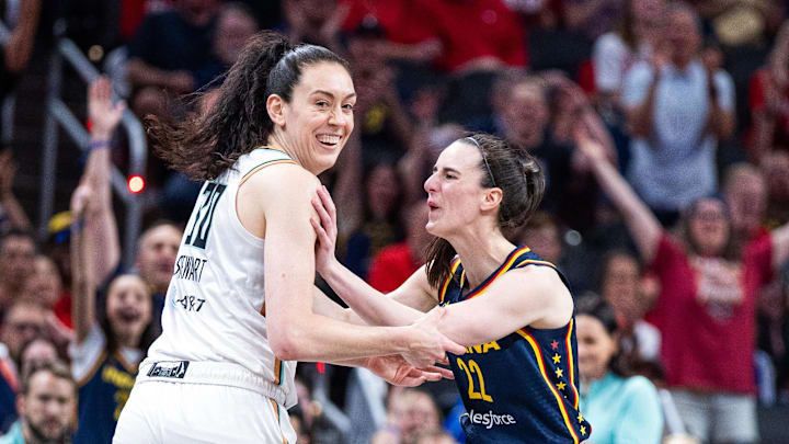 Indiana Fever guard Caitlin Clark (22) celebrates a made basket with New York Liberty forward Breanna Stewart (30)in the first half against the New York Liberty at Gainbridge Fieldhouse.