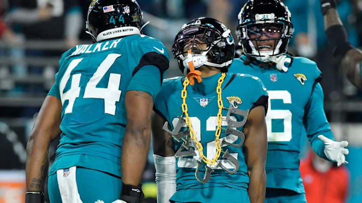 Jacksonville Jaguars cornerback Tyson Campbell (32) celebrates with teammates and a DUVAL chain from