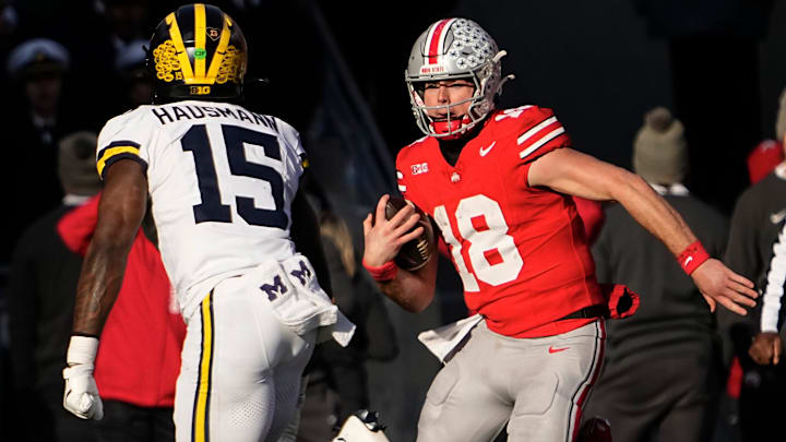 Ohio State quarterback Will Howard runs toward Michigan linebacker Ernest Hausmann. Michigan won 13-10.