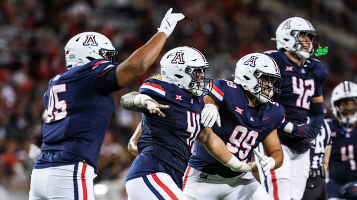 Aug 30, 2025; Tucson, Arizona, USA; Arizona Wildcats defensive lineman Leroy Palu (95), defensive lineman Julian Savaiinaea (41), defensive lineman Mays Pese (99), and defensive lineman Dominic Lolesio (42) all celebrate after they intercept the ball from the Hawaii Rainbow Warriors during the third quarter at Arizona Stadium. Mandatory Credit: Aryanna Frank-Imagn Images