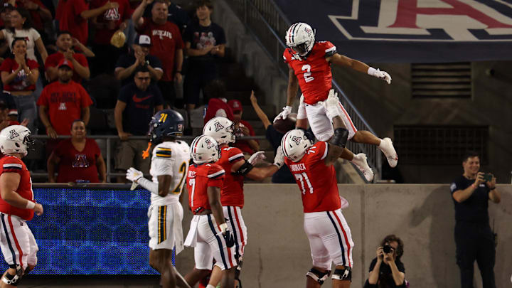 Sep 7, 2024; Tucson, Arizona, USA; Arizona Wildcats wide receiver Jeremiah Patterson (2) celebrates a touchdown with Arizona Wildcats offensive lineman Jonah Savaiinaea (71) during the third quarter against Northern Arizona Lumberjacks at Arizona Stadium.