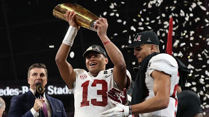 Jan 8, 2018; Atlanta, GA, USA; Alabama Crimson Tide quarterback Tua Tagovailoa (13) celebrates with the trophy after defeating the Georgia Bulldogs 26-23 in the 2018 CFP national championship college football game at Mercedes-Benz Stadium. Mandatory Credit: Matthew Emmons-Imagn Images