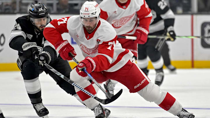Nov 16, 2024; Los Angeles, California, USA; Detroit Red Wings center Dylan Larkin (71) controls the puck from Los Angeles Kings center Phillip Danault (24) in the third period at Crypto.com Arena. Mandatory Credit: Jayne Kamin-Oncea-Imagn Images