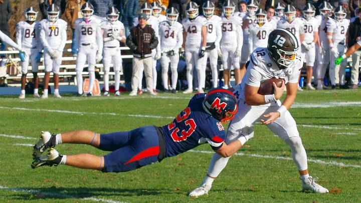 #23 Dionisios Kitsos for Milton Academy looks to take down Brunswick QB Ben Rolapp, but Rolapp slips through for a big gain in the 1st half of the game on Saturday, Nov. 15, 2025. #23 Dionisios Kitsos for Milton Academy looks to take down Brunswick QB Ben Rolapp, but Rolapp slips through for a big gain in the 1st half of the game on Saturday, Nov. 15, 2025.