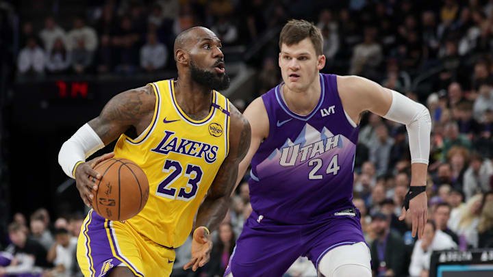 Feb 12, 2025; Salt Lake City, Utah, USA;  Los Angeles Lakers forward LeBron James (23) dribbles past Utah Jazz center Walker Kessler (24) during the first quarter at Delta Center. Mandatory Credit: Chris Nicoll-Imagn Images