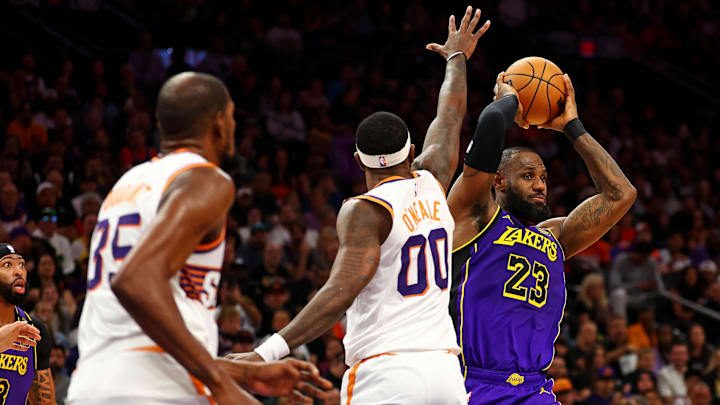 Oct 28, 2024; Phoenix, Arizona, USA; Los Angeles Lakers forward LeBron James (23) handles the ball against Phoenix Suns forward Royce O'Neale (00) at Footprint Center. Mandatory Credit: Mark J. Rebilas-Imagn Images