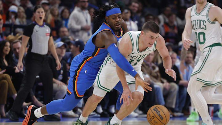 Mar 12, 2026; Oklahoma City, Oklahoma, USA; Oklahoma City Thunder guard Luguentz Dort (5) reaches around Boston Celtics guard Payton Pritchard (11) during the second quarter at Paycom Center. Mandatory Credit: Alonzo Adams-Imagn Images