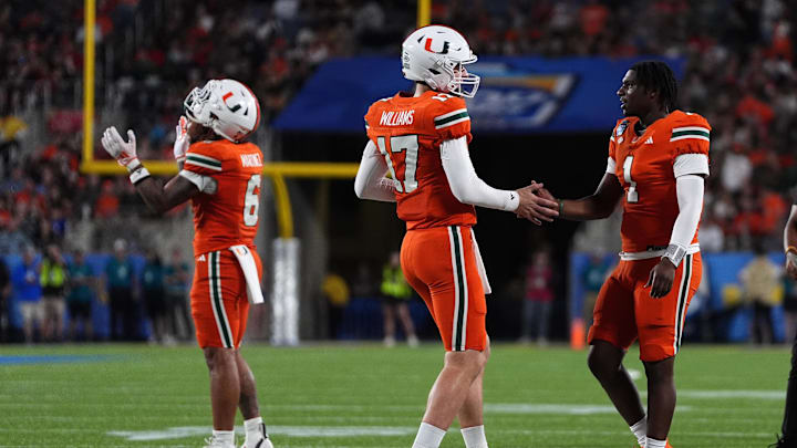 Dec 28, 2024; Orlando, FL, USA; Miami Hurricanes quarterback Emory Williams (17) shakes hands with quarterback Cam Ward (1) after a touchdown against the Iowa State Cyclones during the second half at Camping World Stadium. Mandatory Credit: Jasen Vinlove-Imagn Images