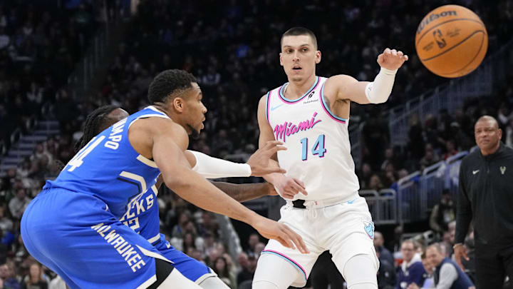 Feb 23, 2025; Milwaukee, Wisconsin, USA;  Miami Heat guard Tyler Herro (14) passes the ball away from Milwaukee Bucks forward Giannis Antetokounmpo (34) during the third quarter at Fiserv Forum. Mandatory Credit: Jeff Hanisch-Imagn Images