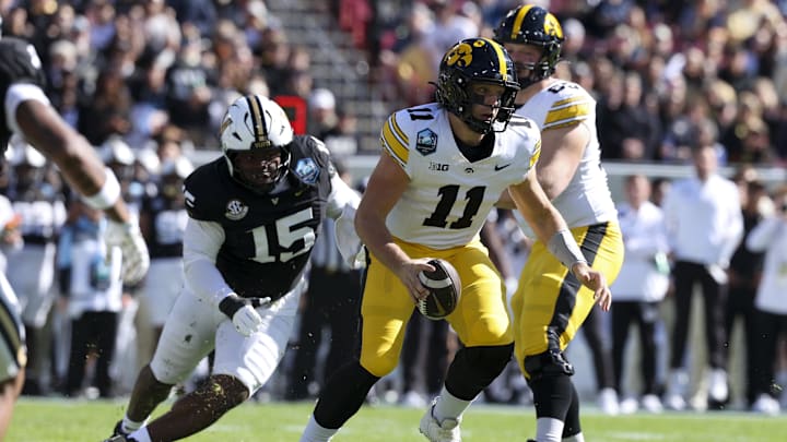Dec 31, 2025; Tampa, FL, USA; Iowa Hawkeyes quarterback Mark Gronowski (11) scrambles out of the pocket against the Vanderbilt Commodores in the first quarter during the ReliaQuest Bowl at Raymond James Stadium. Mandatory Credit: Nathan Ray Seebeck-Imagn Images