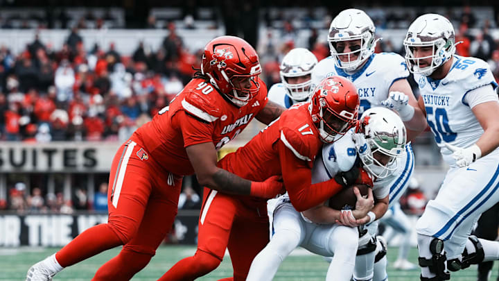 Louisville Cardinals defensive lineman AJ Green (17) grabs Kentucky Wildcats quarterback Cutter Boley (8) as Louisville Cardinals defensive lineman Clev Lubin (50) helps in the first half Saturday, November 29, 2025 in Louisville, Kentucky at L&N Federal Credit Union Stadium.