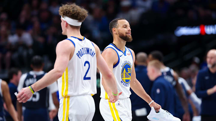 Apr 5, 2024; Dallas, Texas, USA;  Golden State Warriors guard Stephen Curry (30) reacts with Golden State Warriors guard Brandin Podziemski (2) after losing his shoe during the first half against the Dallas Mavericks at American Airlines Center. Mandatory Credit: Kevin Jairaj-Imagn Images